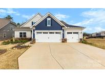 Charming two-story home featuring a two-car garage, well-manicured lawn, and beautiful landscaping at 21110 Bank Fire Ln, Huntersville, NC 28078