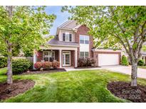 Charming two-story brick home featuring a well-manicured lawn and inviting front porch at 219 Pleasant Grove Ln, Mooresville, NC 28115