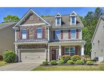 Charming two-story home featuring a stone facade, dormer windows, a two-car garage, and beautifully landscaped front yard at 79115 Ridgehaven Rd, Lancaster, SC 29720