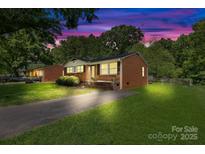 Beautiful brick home with manicured lawn at dusk, featuring inviting exterior lighting and a serene ambiance at 1053 Stoneybrook Ln, Rock Hill, SC 29730