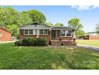 Charming single-story brick home with a well-maintained lawn and mature landscaping, exuding curb appeal at 1053 Stoneybrook Ln, Rock Hill, SC 29730