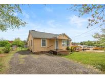 Charming single-Gathering home featuring a cozy front porch and gravel driveway at 127 Bristol Rd, Statesville, NC 28677