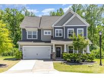 Charming two-story home featuring a two-car garage, stone accents, and a well-maintained front yard with mature trees at 1552 Trentwood Dr, Fort Mill, SC 29715