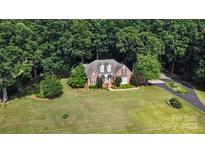 Sprawling brick home set on a large lush lot surrounded by mature trees at 15546 Thompson Rd, Mint Hill, NC 28227