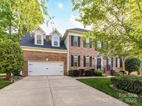 Charming two-story brick home with a well-manicured lawn and a two-car garage at 6005 Abergele Ln, Matthews, NC 28104