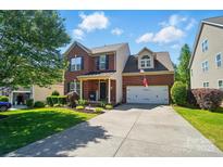 Charming two-story brick home with a well-manicured lawn and a two-car garage on a sunny day at 8004 Fountainbrook Dr # 15, Indian Trail, NC 28079