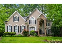 Charming two-story home with a stone entryway and a lush green lawn at 10319 Remembrance Trl, Huntersville, NC 28078