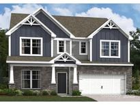 Charming two-story home featuring stone accents, blue siding, gabled roof, and an attached two-car garage at 1215 Fremont Dr, Wingate, NC 28174