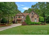 Stunning stone and brick home with a manicured lawn and lush landscaping, exuding curb appeal at 1305 Anniston Pl, Wesley Chapel, NC 28079