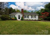 Charming single-story home with a brick chimney, well-manicured lawn, and beautiful landscaping at 166 Still Ave, Fort Mill, SC 29715
