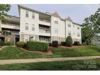 Attractive condo building featuring multiple balconies, manicured landscaping, and architectural detail at 18711 Ruffner Dr # 1A, Cornelius, NC 28031
