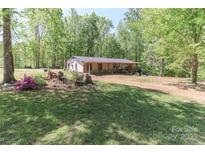 Inviting single-story home featuring a charming front porch and a spacious front yard at 212 Davies Cir, Cleveland, NC 27013