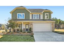 Charming two-story home with a stone-accented facade, two-car garage, and well-maintained landscaping at 247 Tackle Box Dr, Troutman, NC 28166
