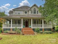 Stunning two-story home boasting a charming wrap-around porch with beautiful landscaping and an inviting entrance at 3231 Karen Ln, Monroe, NC 28110