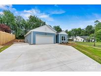 Charming blue home with a spacious concrete driveway and an attached garage at 3567 Farmfield Dr, Claremont, NC 28610