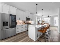 Modern kitchen featuring stainless steel appliances, white cabinetry, and a large center island with seating at 4002 Tundra Rd, Charlotte, NC 28203