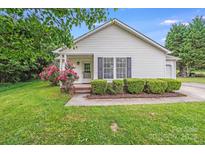 Charming single-story home featuring manicured lawn, flowering bushes, and neutral siding with classic curb appeal at 4227 Coopersdale Rd, Charlotte, NC 28273