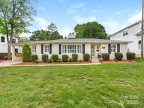 Charming home featuring a manicured lawn, brick facade, and well-maintained landscaping at 4346 Walker Rd, Charlotte, NC 28211