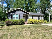 Charming one-story home featuring gray siding, black shutters, and mature landscaping at 440 Mt Moriah Church Rd, China Grove, NC 28023