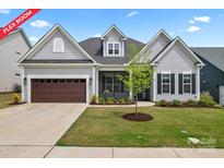 Charming home featuring a screened porch, a brown garage door, and a beautifully landscaped front yard at 471 Lucky Nw Dr, Concord, NC 28027