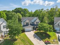 Traditional two-story home with manicured lawn and a driveway, surrounded by mature trees at 4853 Walnut Grove St, Harrisburg, NC 28075