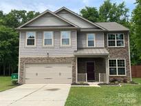 Charming two-story home with stone and siding, featuring a two-car garage and landscaped front yard at 5619 Fenway Dr, Charlotte, NC 28273