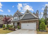 Beautiful two-story home with stone and gray shingle exterior and a two-car garage at 1548 Striped Bass Ln, Clover, SC 29710