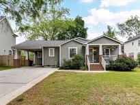 Charming single-story home with gray siding, well-maintained lawn, brick accents, and covered carport at 335 Greystone Rd, Charlotte, NC 28209