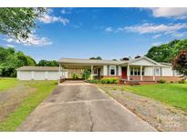 Charming single-story home featuring a brick foundation, covered carport, and detached garage with ample parking space at 543 18Th Nw St, Hickory, NC 28601