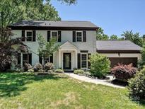 Charming white brick home with dark shutters, a manicured lawn and attached two-car garage at 8200 Lansford Rd, Charlotte, NC 28277