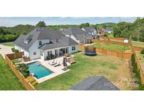 Beautiful backyard featuring a pool, lounge chairs, patio, fire pit, and a trampoline at 959 Robinson Rd, Gastonia, NC 28056