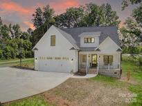Stunning two-story home featuring a manicured lawn, welcoming front porch, and attached two-car garage at 1030 Little Cowgirl Ln, Cleveland, NC 27013
