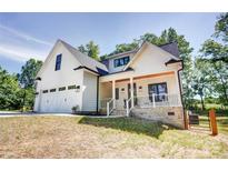 Charming two-story home with a white exterior, black trim, and a welcoming front porch at 1030 Little Cowgirl Ln, Cleveland, NC 27013