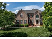 Traditional two-story brick home with manicured lawn and shuttered windows at 1116 Crooked River Dr, Waxhaw, NC 28173
