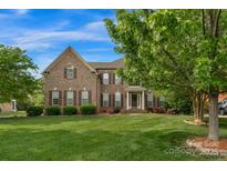 Charming brick two-story home with a lush green lawn and mature landscaping creating a welcoming curb appeal at 1116 Crooked River Dr, Waxhaw, NC 28173