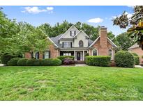 Charming brick home with manicured lawn, lush landscaping and detailed architectural features at 1200 Churchill Downs Dr, Waxhaw, NC 28173