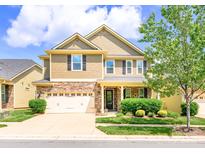 Charming two-story home featuring a stone facade, two-car garage, and manicured front lawn at 121 Martingale Ave, Mooresville, NC 28115