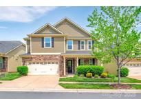 Inviting two-story home with a stone and shingle facade, two-car garage, manicured lawn, and well-maintained landscaping at 121 Martingale Ave, Mooresville, NC 28115