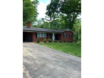 Charming brick home featuring a well-manicured lawn, a cozy front porch and driveway at 137 Deal Ln, Statesville, NC 28677