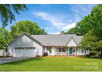 Charming single-story home with a teal front door, lush green lawn, and a welcoming front porch at 1666 Sam Smith Rd, Fort Mill, SC 29708
