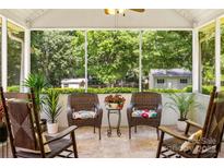 Inviting screened porch with rocking chairs and view of landscaped backyard at 1666 Sam Smith Rd, Fort Mill, SC 29708