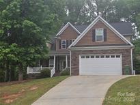 Charming two-story home features a two car garage and a combination of stone, siding, and shake exterior finishes at 4203 Flint Dr, Lancaster, SC 29720