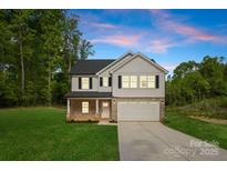 Charming two-story home featuring a brick and white exterior, attached garage, and a well-manicured lawn at 5115 Carden Dr, Charlotte, NC 28227