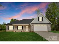 Charming single-story brick home with a well-manicured lawn and attached two-car garage at 5209 Carden Dr, Charlotte, NC 28227