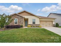 Charming single-story home featuring a well-manicured lawn, stone accents, and an attached two-car garage at 5247 Looking Glass Trl, Denver, NC 28037