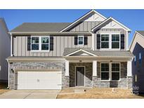 Two-story home featuring a stone facade, a white garage door, and black shutters for a modern and elegant curb appeal at 60 Sherwood Nw Ct, Concord, NC 28027