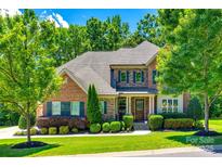 Charming brick home featuring manicured landscaping, green shutters, and a welcoming front porch at 618 Chase Ct, Fort Mill, SC 29708
