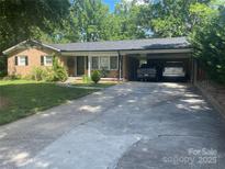 Charming brick home with a spacious carport and well-maintained front lawn and concrete driveway at 734 Harris Nw St, Concord, NC 28025