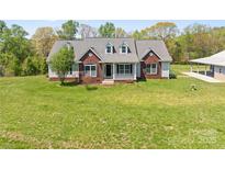 Charming home with brick accents, dormer windows, and a welcoming front porch at 1046 Linneys Mill Rd, Union Grove, NC 28689