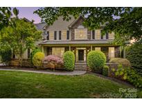 Charming home featuring stone accents, manicured landscaping, a covered porch, and elegant architectural details at 110 Preserve Way, Mooresville, NC 28117